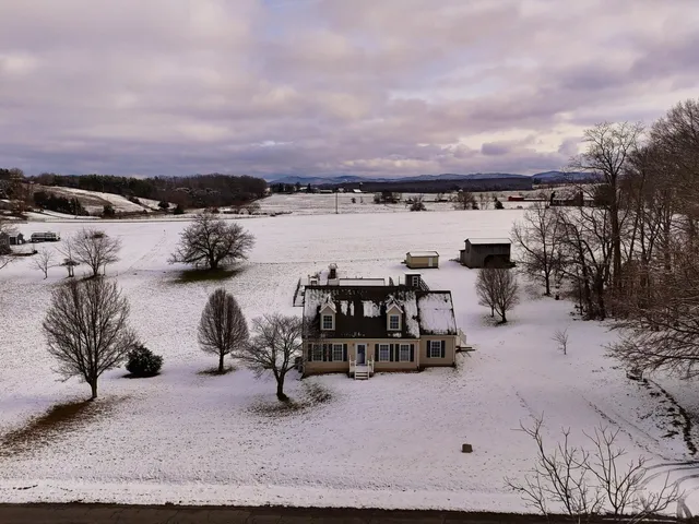 an empty room with wooden floor a fireplace and windows