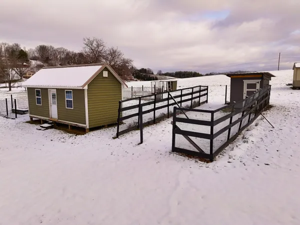 a view of a house with a yard covered in snow