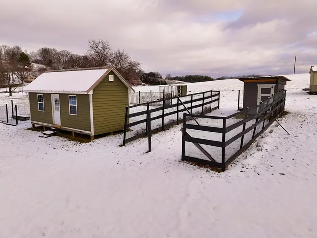 a view of a house with a yard covered in snow