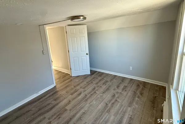 an empty room with wooden floor and entrance