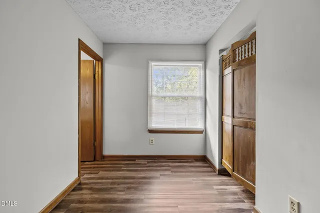 an empty room with wooden floor and a window