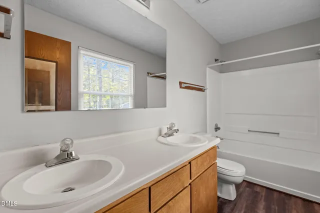 a bathroom with a sink toilet vanity and tub