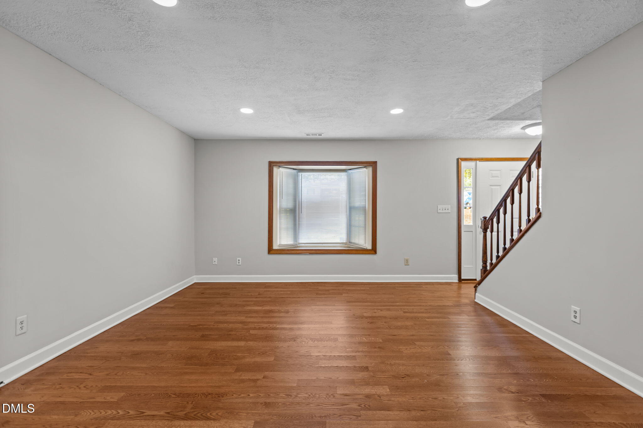 2501 Anne Carol Court Raleigh, NC 27603 - Photo 6 of 36 a view of an empty room with wooden floor and a window