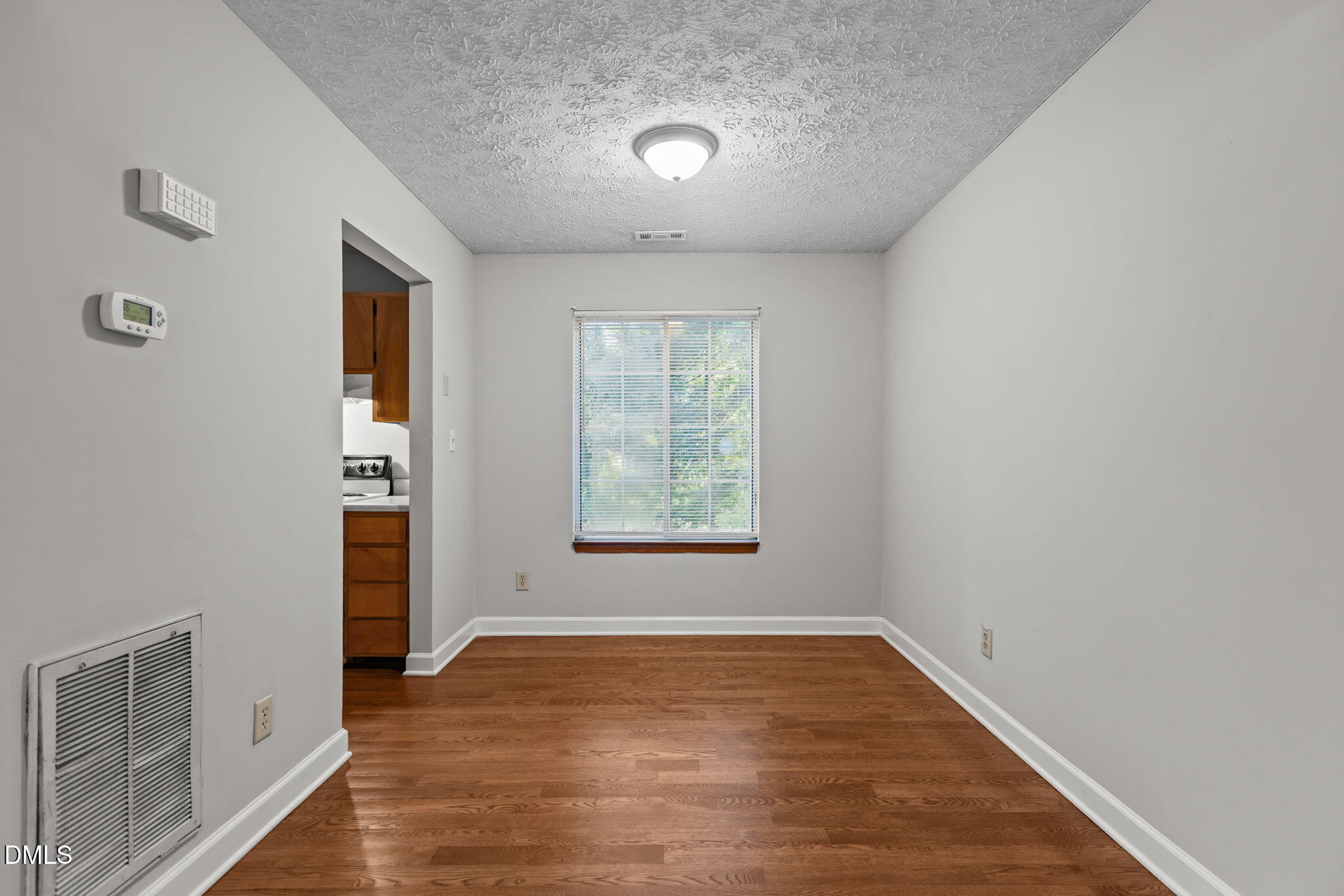 2501 Anne Carol Court Raleigh, NC 27603 - Photo 7 of 36 an empty room with wooden floor and windows