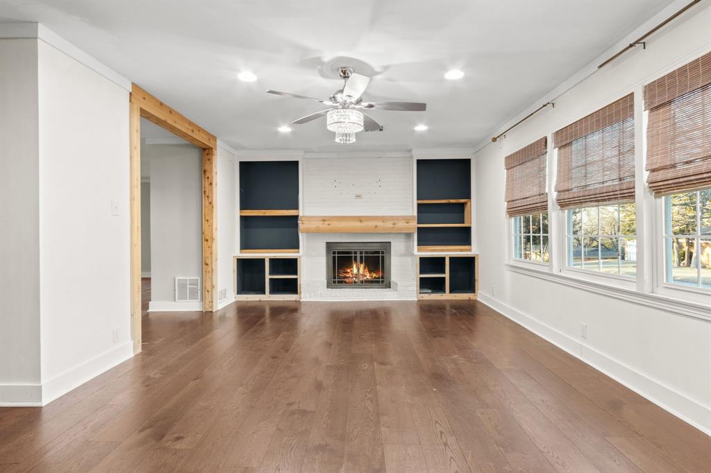 2208 Lake Ridge Circle Waco, TX 76710 - Photo 11 of 40 Unfurnished living room featuring ceiling fan, dark wood finished floors, a brick fireplace, recessed lighting, and built in features