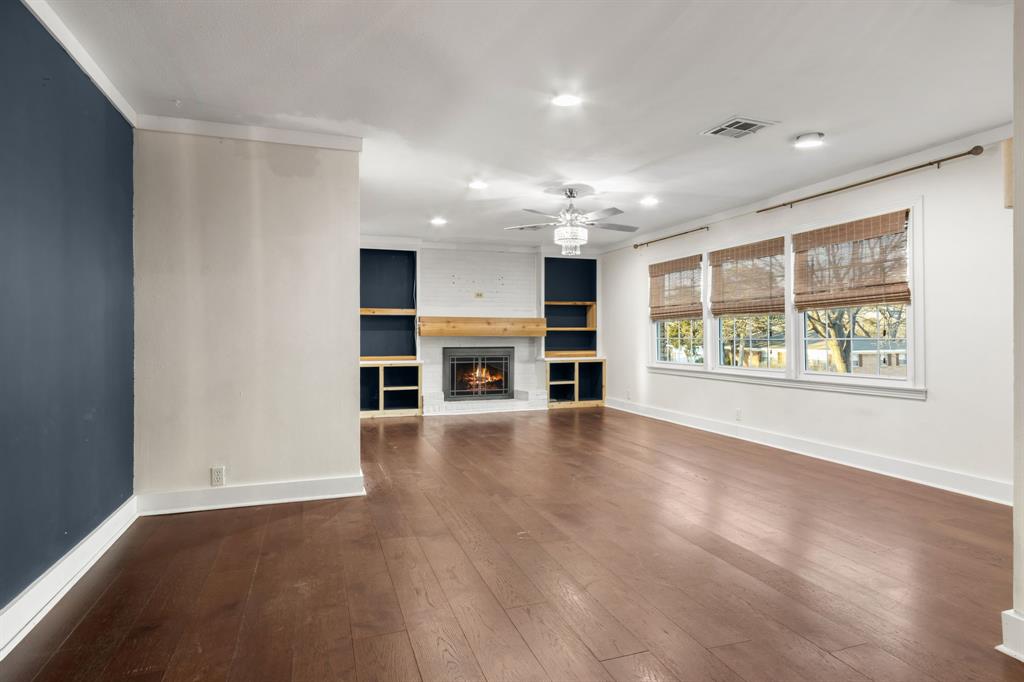 2208 Lake Ridge Circle Waco, TX 76710 - Photo 14 of 40 Unfurnished living room featuring dark wood-style flooring, recessed lighting, a large fireplace, ornamental molding, and a ceiling fan