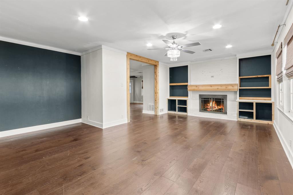 2208 Lake Ridge Circle Waco, TX 76710 - Photo 15 of 40 Unfurnished living room featuring built in features, a ceiling fan, a fireplace, recessed lighting, and dark wood finished floors