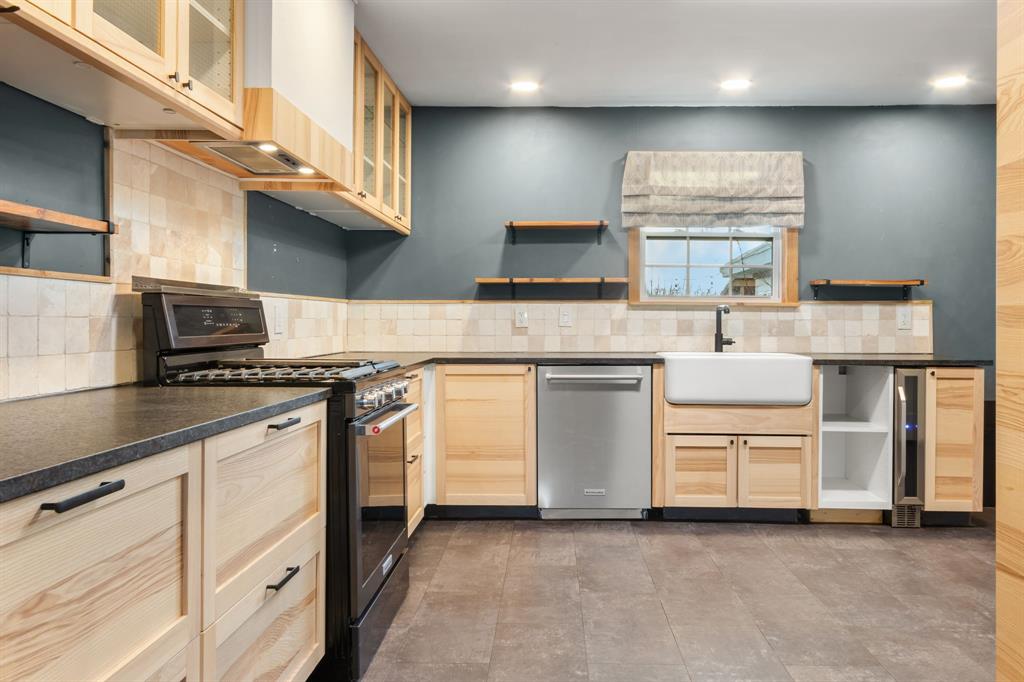 2208 Lake Ridge Circle Waco, TX 76710 - Photo 16 of 40 Kitchen with open shelves, light wood finish cabinetry, black gas range oven, dishwasher, and dark countertops