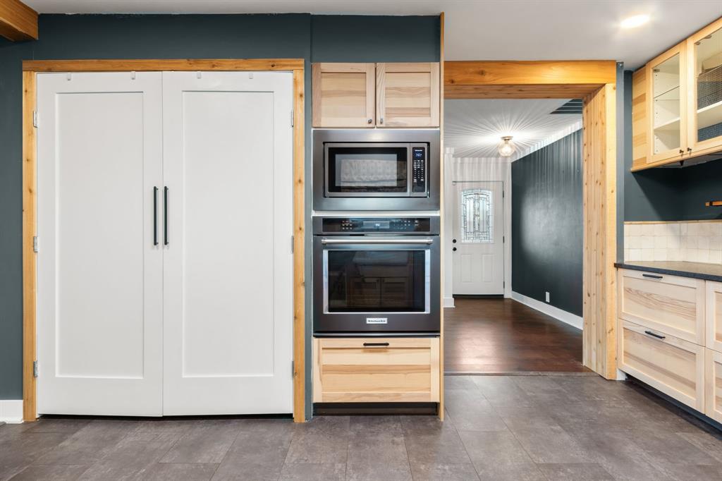 2208 Lake Ridge Circle Waco, TX 76710 - Photo 18 of 40 Kitchen with glass fronted cabinets, light wood finish cabinets, stainless steel appliances, and dark countertops