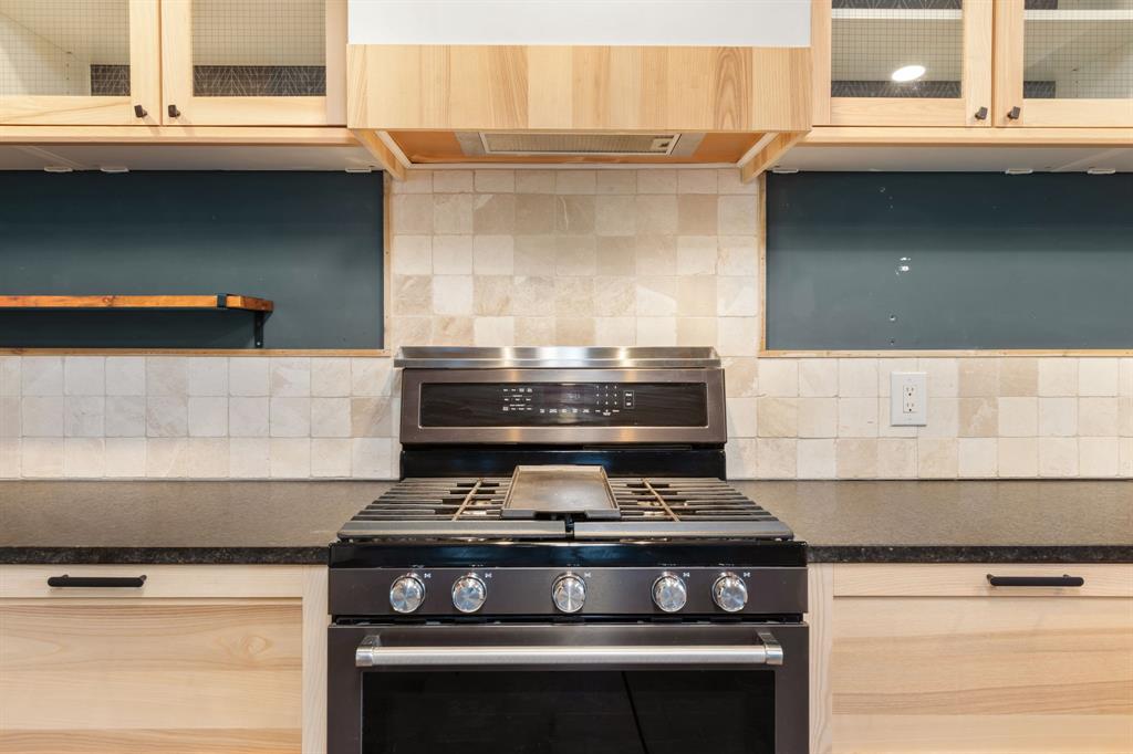 2208 Lake Ridge Circle Waco, TX 76710 - Photo 19 of 40 Kitchen featuring glass insert cabinets, stainless steel range with gas cooktop, light wood finish cabinetry, and decorative backsplash