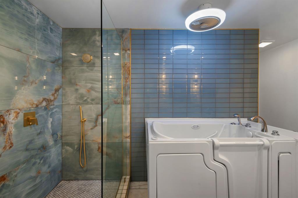 2208 Lake Ridge Circle Waco, TX 76710 - Photo 32 of 40 Bathroom with a walk in shower, a garden tub, and tile walls