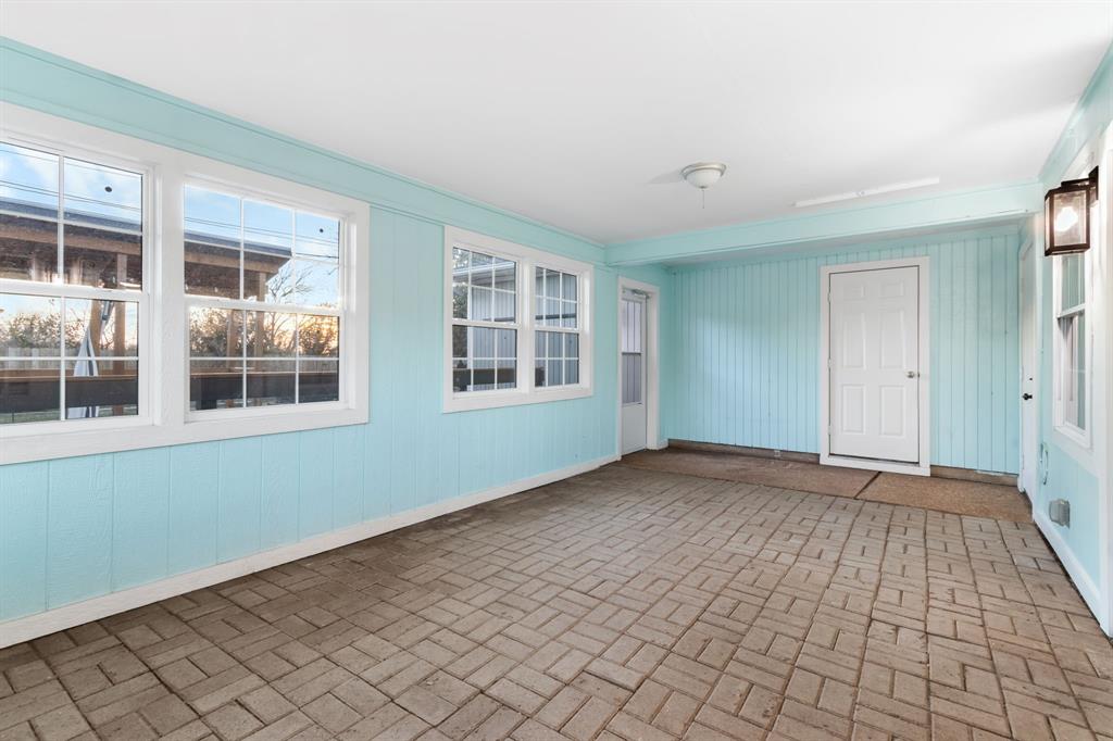 2208 Lake Ridge Circle Waco, TX 76710 - Photo 35 of 40 Unfurnished sunroom with brick patterned flooring and wood walls