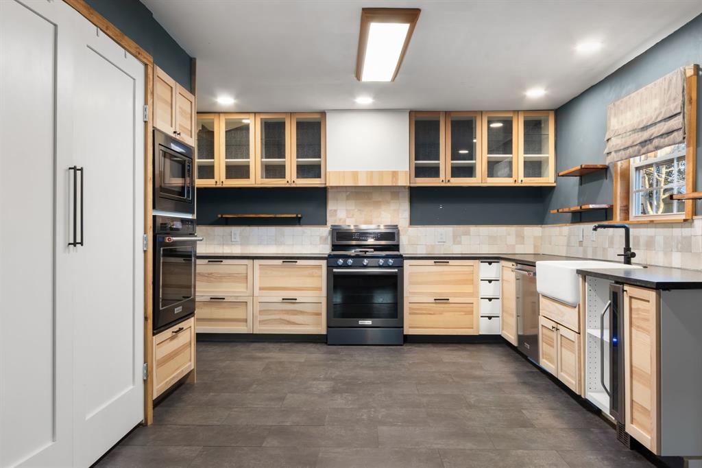 2208 Lake Ridge Circle Waco, TX 76710 - Photo 4 of 40 Kitchen with light wood finish cabinetry, open shelves, black appliances, decorative backsplash, and wine cooler
