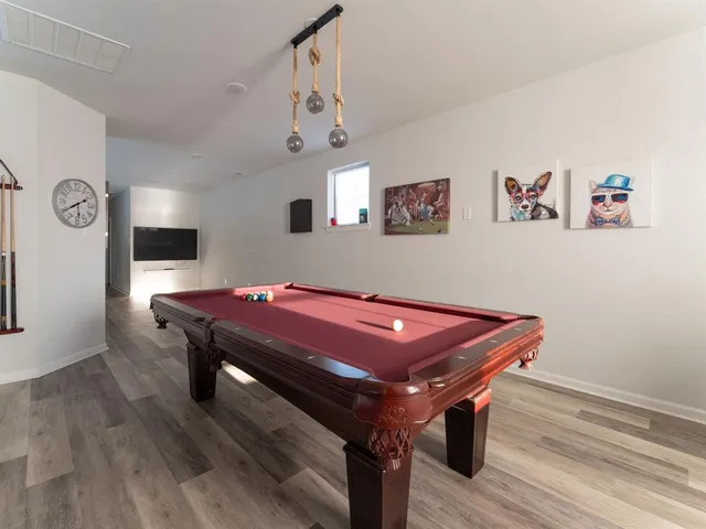 a room with pool table and windows