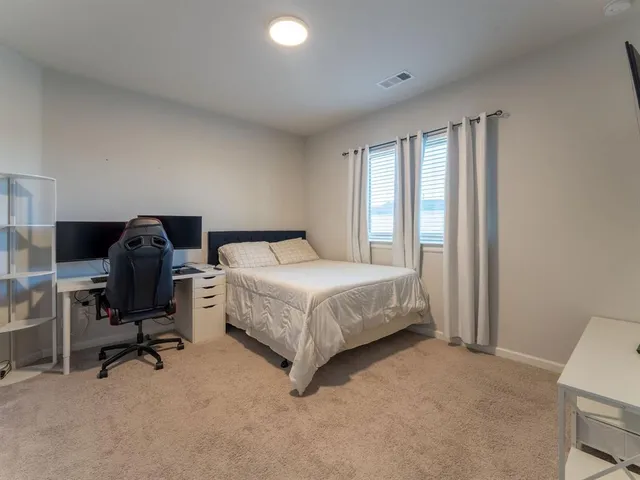 a bedroom with a bed a desk and chair