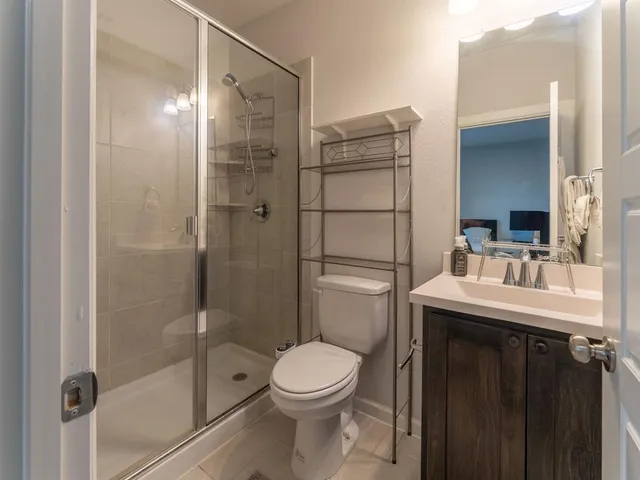 a bathroom with a granite countertop sink toilet and shower