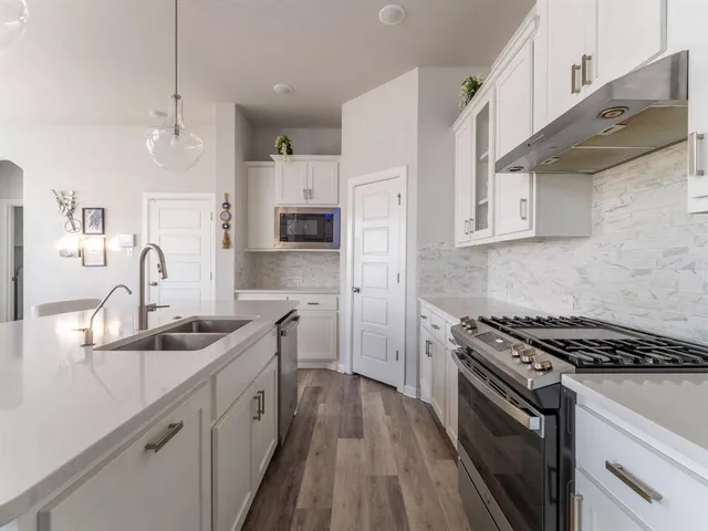 a kitchen with stainless steel appliances a sink stove and cabinets