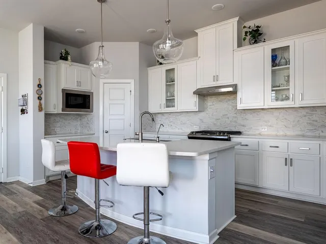 a kitchen with stainless steel appliances granite countertop a kitchen island hardwood floor sink stove and microwave