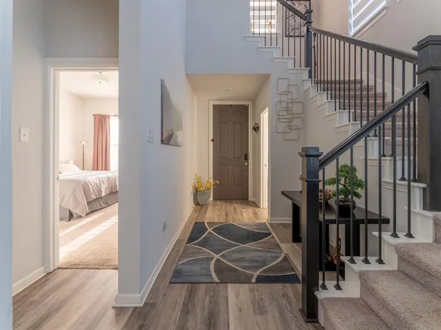 a view of a hallway with wooden floor and staircase