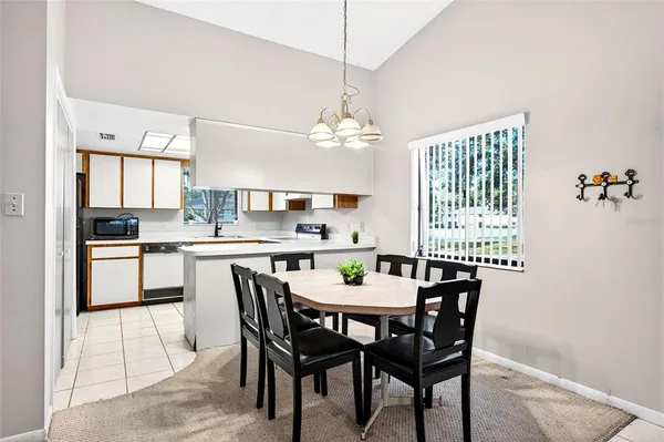 a dining room with a table chairs and a kitchen view