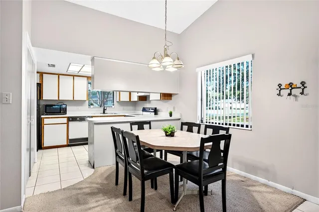 a dining room with a table chairs and a kitchen view