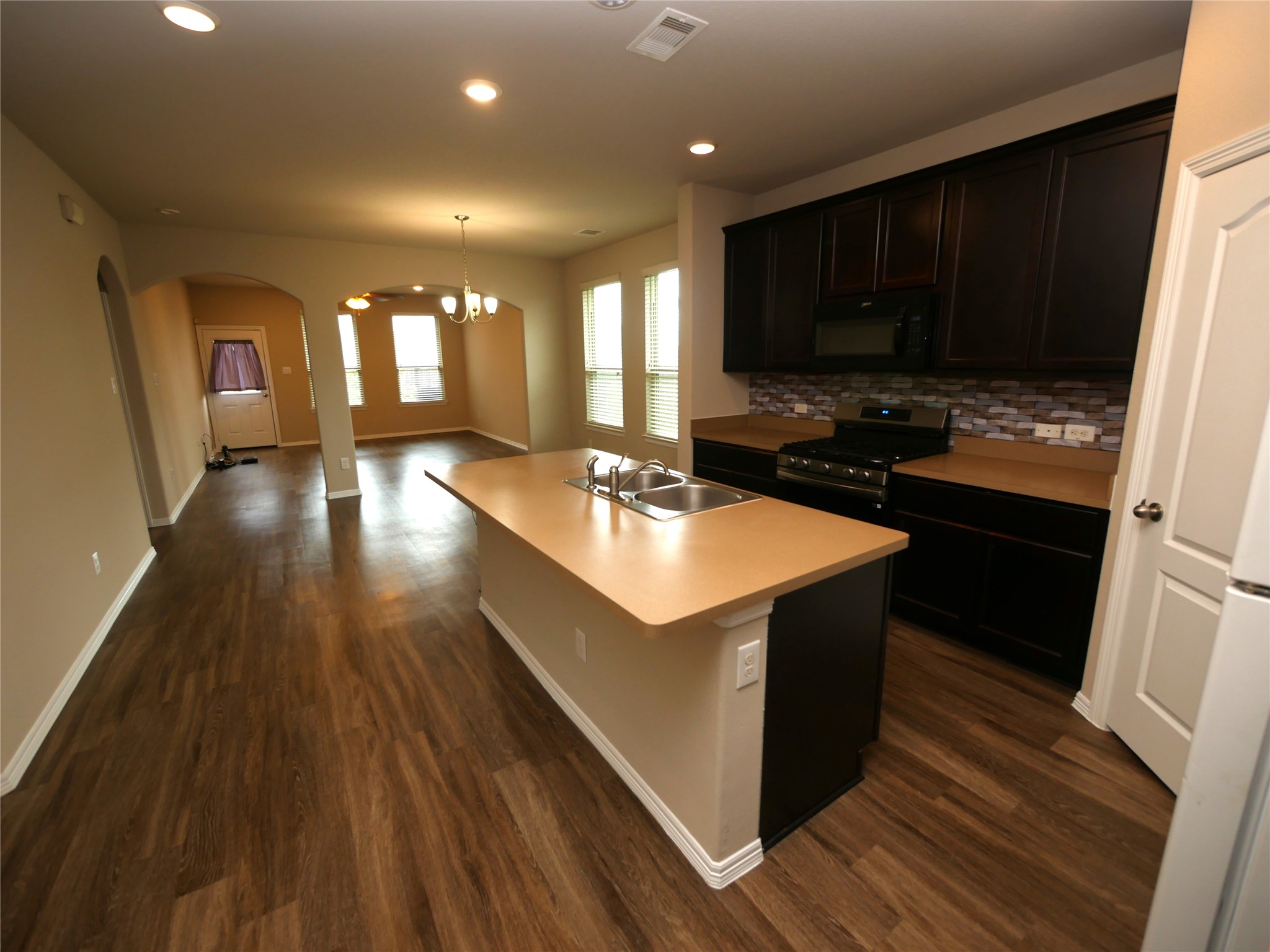 Open-concept kitchen featuring a functional island, ample workspace, and a NEW stove. The layout flows easily into the main living area for everyday living and entertaining.
