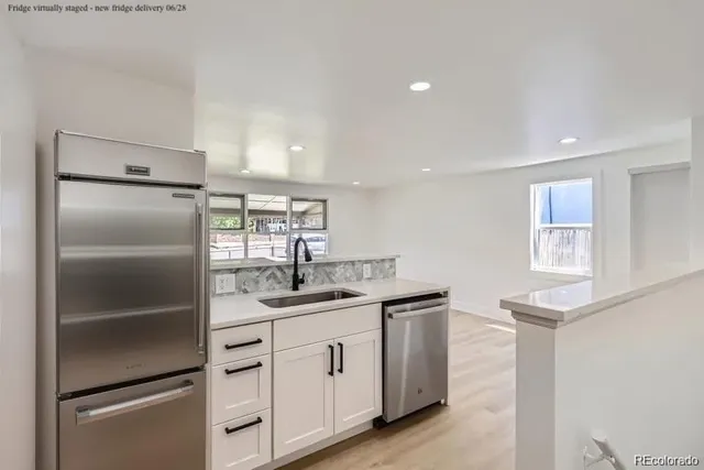 a kitchen with white cabinets and appliances