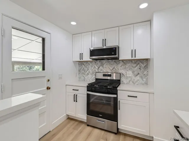 a kitchen with stainless steel appliances a stove a sink and a microwave