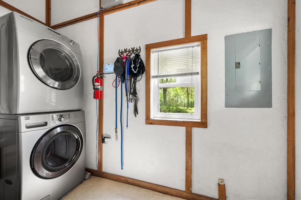 126 Smallwood Court Springtown, TX 76082 - Photo 18 of 24 Large Dedicated laundry area featuring a stacked washer and dryer, a window with blinds, and exposed wood framing