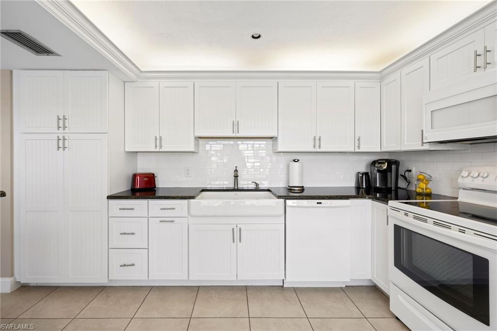 108 Penny Lane, Unit 4 Naples, FL 34112 - Photo 11 of 31 a kitchen with cabinets stainless steel appliances and sink