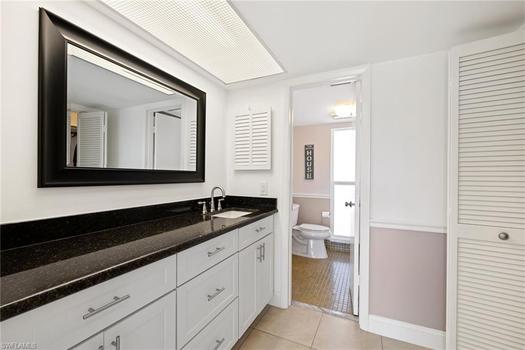 108 Penny Lane, Unit 4 Naples, FL 34112 - Photo 17 of 31 a bathroom with a granite countertop sink and a mirror