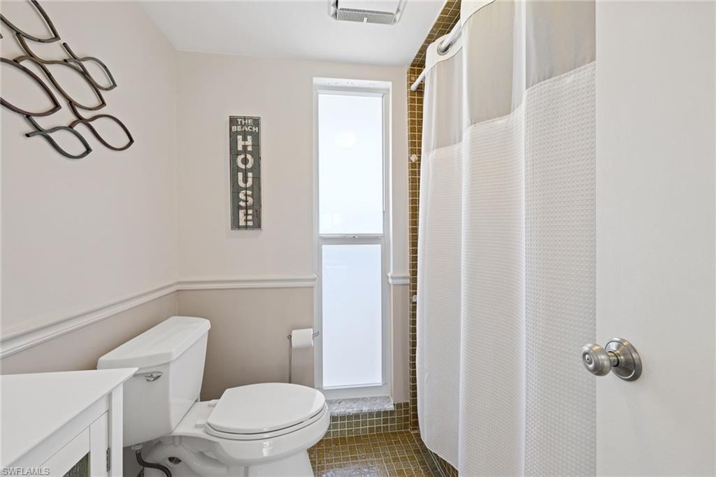 108 Penny Lane, Unit 4 Naples, FL 34112 - Photo 18 of 31 a white toilet sitting next to a bathroom sink
