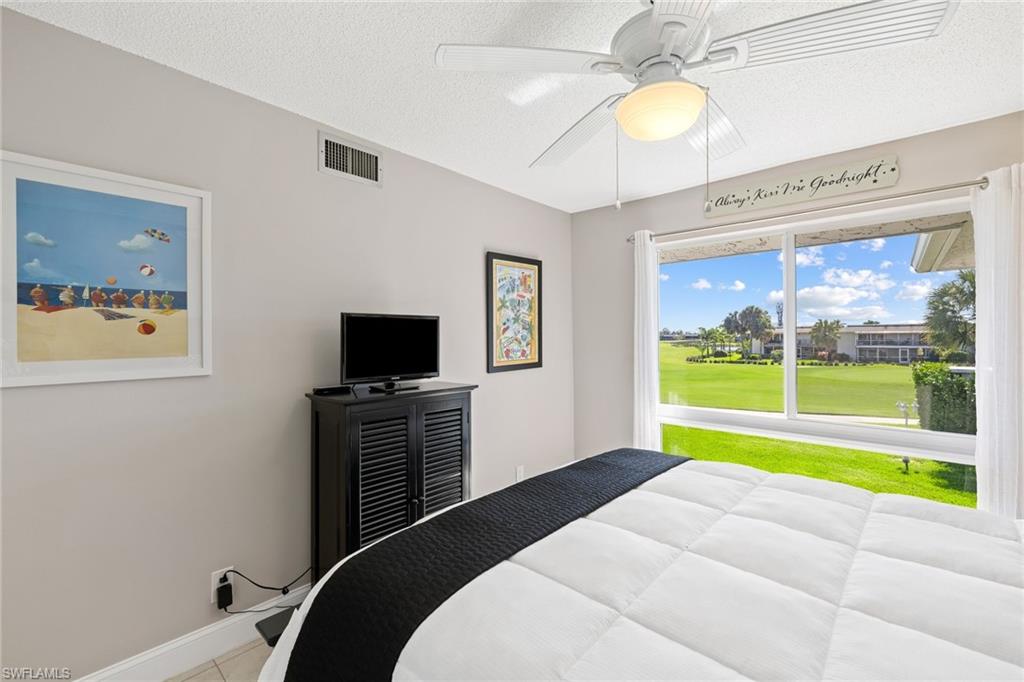 108 Penny Lane, Unit 4 Naples, FL 34112 - Photo 21 of 31 a bedroom with a bed and a flat screen tv