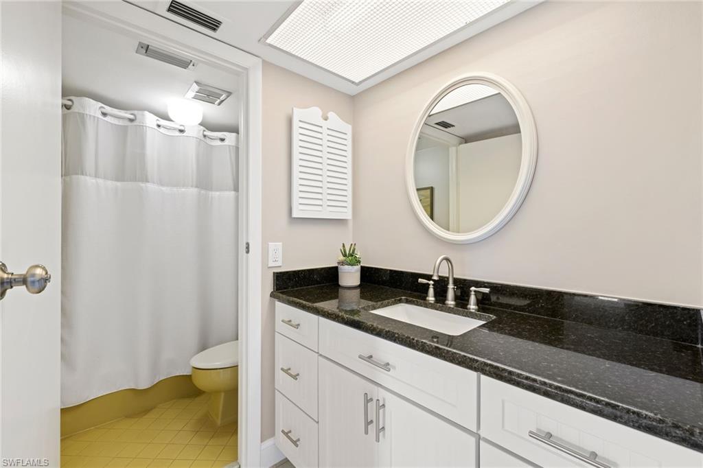 108 Penny Lane, Unit 4 Naples, FL 34112 - Photo 22 of 31 a bathroom with a granite countertop sink and a mirror