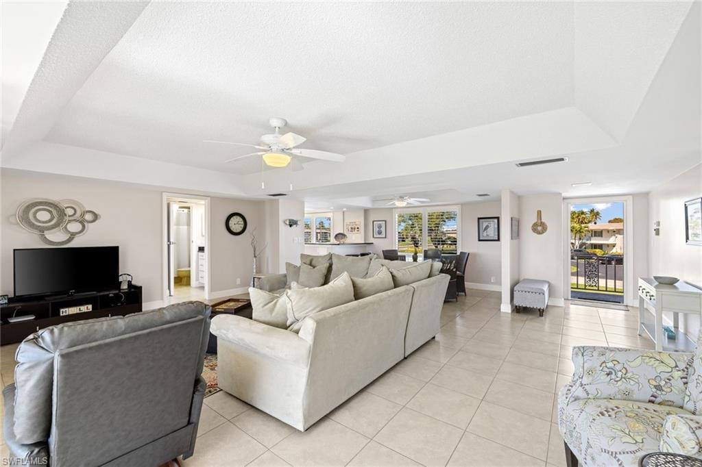 108 Penny Lane, Unit 4 Naples, FL 34112 - Photo 30 of 31 a living room with furniture and a flat screen tv