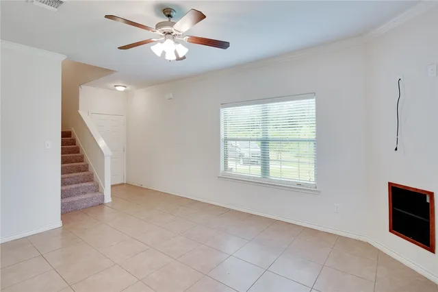a view of an empty room with a window and a ceiling fan