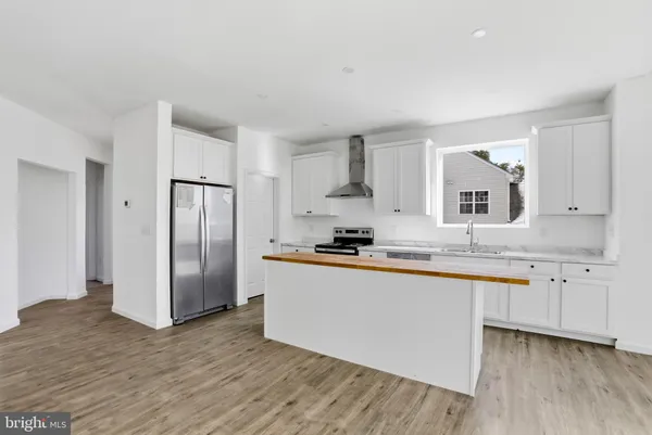a kitchen with granite countertop a refrigerator and a sink