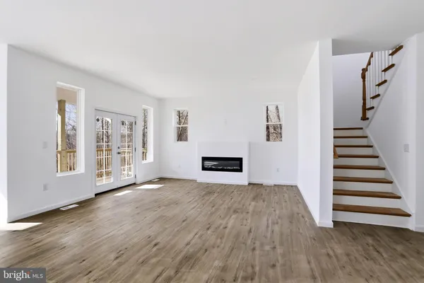 a view of a livingroom with wooden floor and stairs