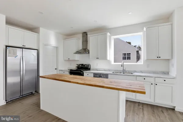 a kitchen with stainless steel appliances granite countertop a sink a refrigerator and a stove