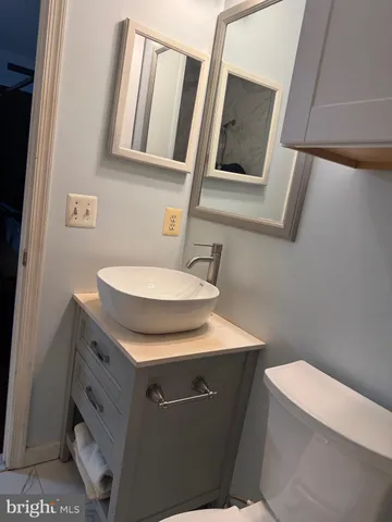 a bathroom with a toilet a sink and mirror