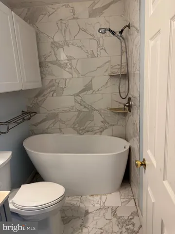 a white bath tub sitting next to a toilet