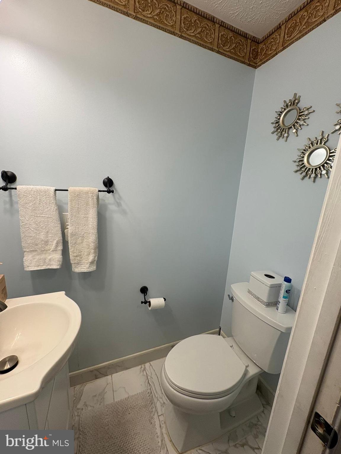 7148 Natures Road Columbia, MD 21046 - Photo 9 of 49 a white toilet sitting next to a bathroom sink and a mirror