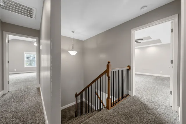 an empty room with ceiling fan and windows