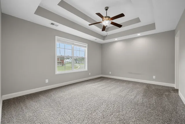 en empty room with fan and a ceiling fan