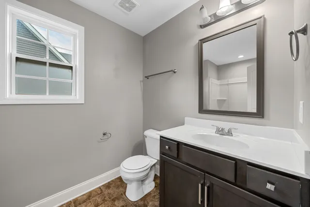 an empty room with a window and ceiling fan