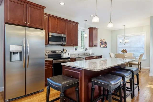 a kitchen with stainless steel appliances a table chairs refrigerator and microwave