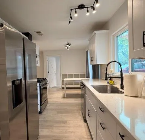 a large kitchen with a refrigerator and a sink