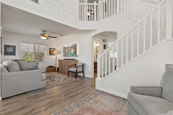 a living room with couches and a dining table with wooden floor
