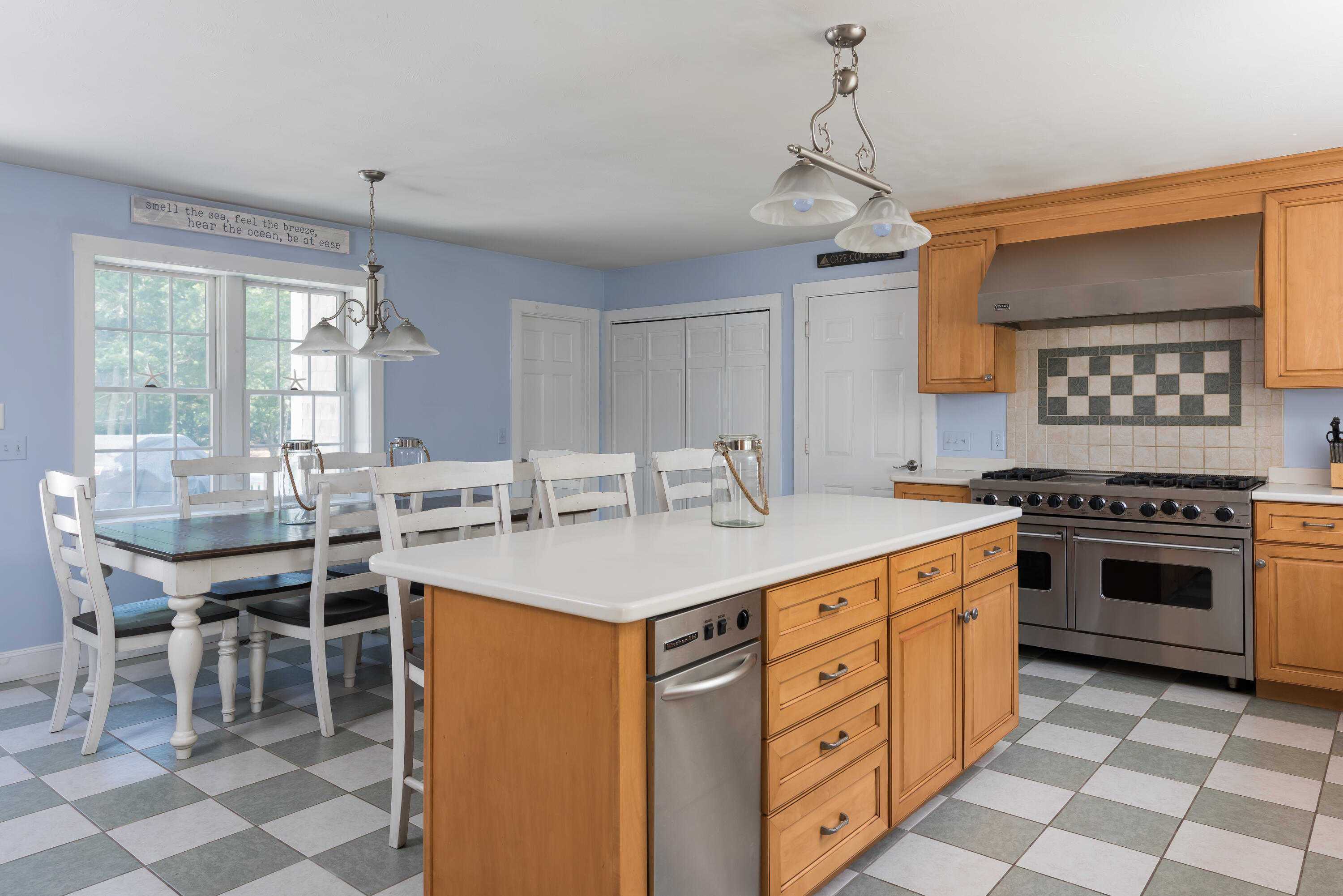125 Lakeview Drive Centerville, MA 02632 - Photo 7 of 28 a kitchen with a stove a sink a dining table and chairs
