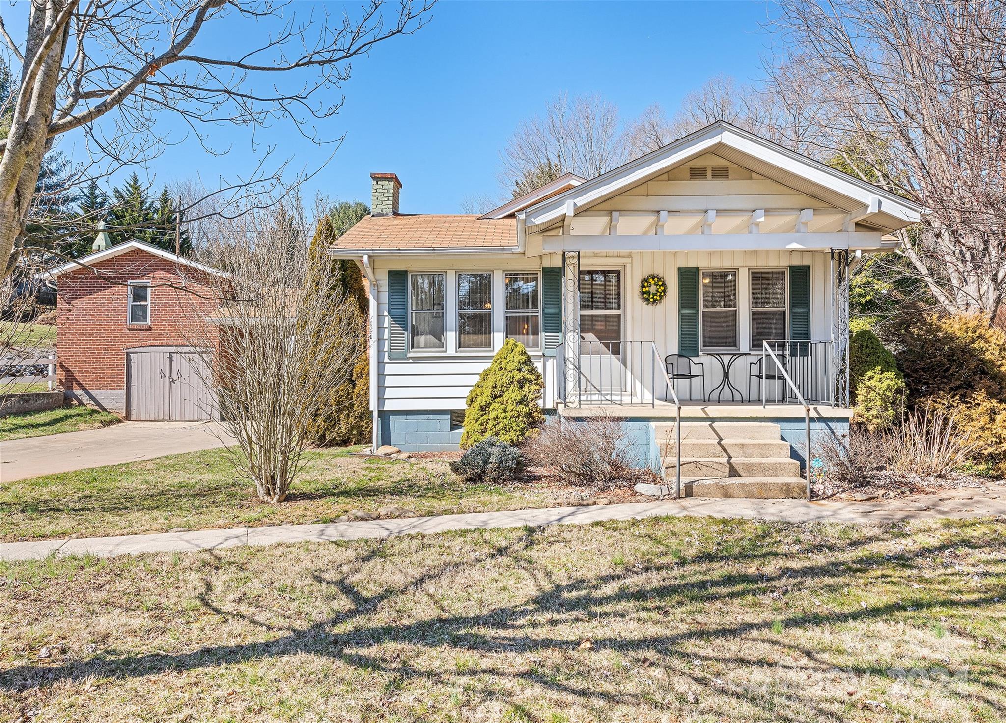 1671 Old Clyde Road Clyde, NC 28721 - Photo 1 of 24 a front view of a house with a yard and potted plants